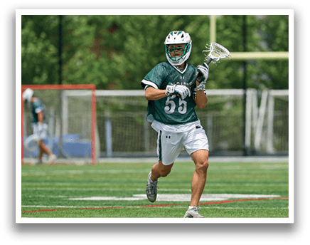 A man wearing a green and white shirt and white shorts is running with a lacrosse stick. Description generated by AI