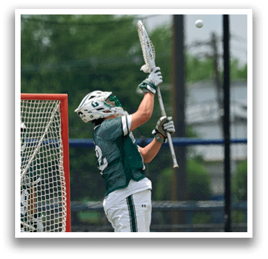 Two men wearing green jerseys and white shorts are standing on a field. Description generated by AI