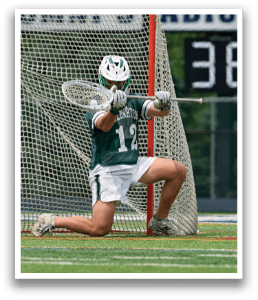 A man running on a field with a lacrosse stick. Description generated by AI