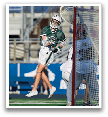A man holding a lacrosse stick. Description generated by AI