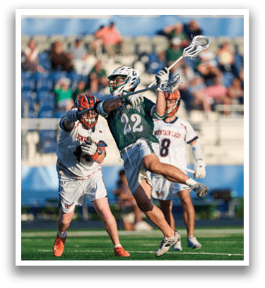A man holding a lacrosse stick. Description generated by AI