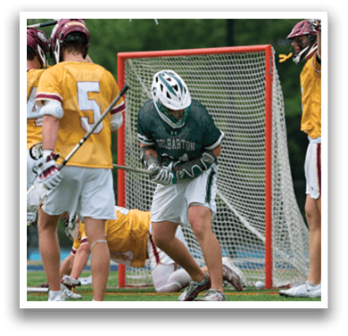 A man holding a lacrosse net. Description generated by AI