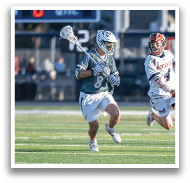 A man holding a lacrosse stick. Description generated by AI