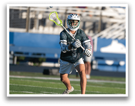A man wearing a green and white shirt and white shorts is running with a lacrosse stick. Description generated by AI