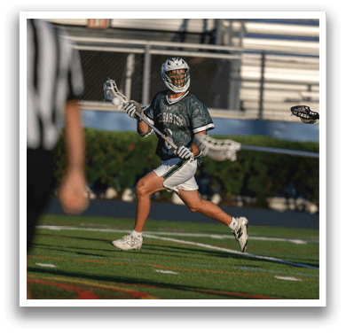 Two men wearing green jerseys and white shorts are standing on a field. Description generated by AI