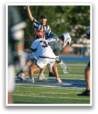 A man wearing a green shirt and white shorts is playing lacrosse. Description generated by AI