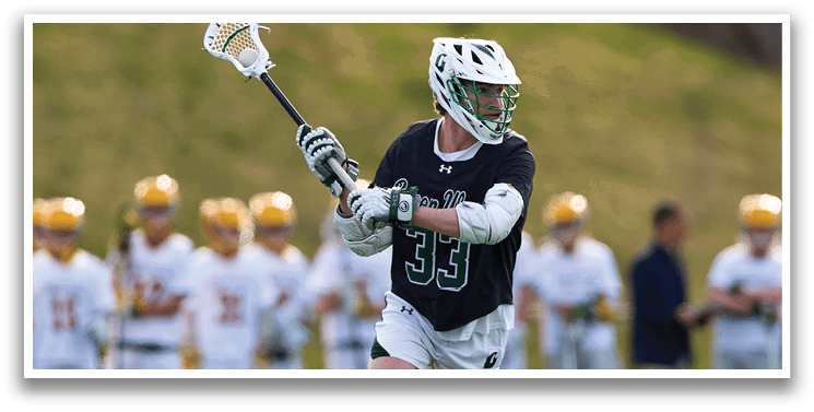A man holding a lacrosse stick. Description generated by AI