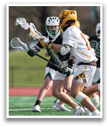 A group of men playing lacrosse on a field. Description generated by AI