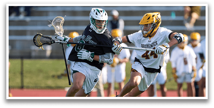 Two men playing lacrosse on a field. Description generated by AI