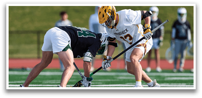 Two men playing hockey on a field. Description generated by AI