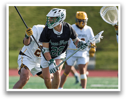 A man wearing a black shirt and white shorts is holding a lacrosse stick. Description generated by AI