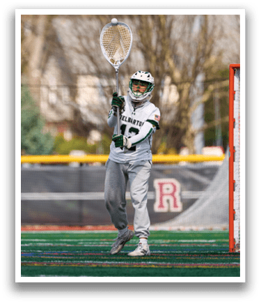 A person wearing a white and green uniform is holding a lacrosse stick. Description generated by AI