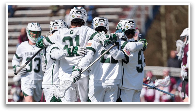 A group of people wearing white uniforms and holding hockey sticks. Description generated by AI