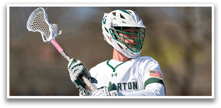 A man holding a lacrosse stick. Description generated by AI