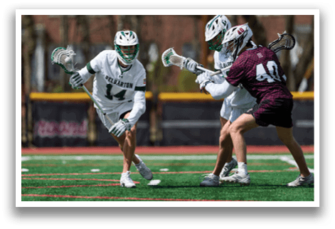 Two men playing lacrosse on a field. Description generated by AI
