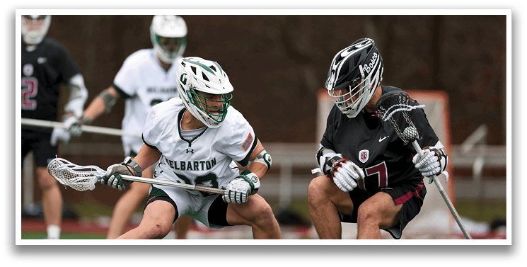 Two men playing lacrosse on a field. Description generated by AI