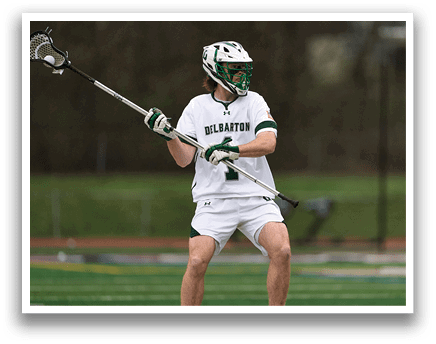 A man wearing a white uniform holding a lacrosse stick. Description generated by AI