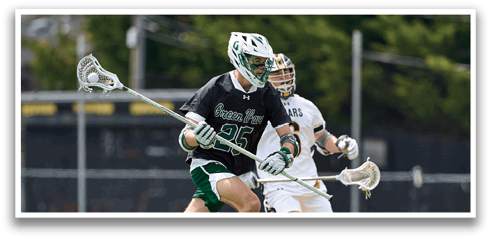 A man in a black shirt and green shorts is running with a lacrosse stick. Description generated by AI