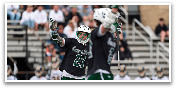 A man wearing a green and white jersey is holding up his arms. Description generated by AI