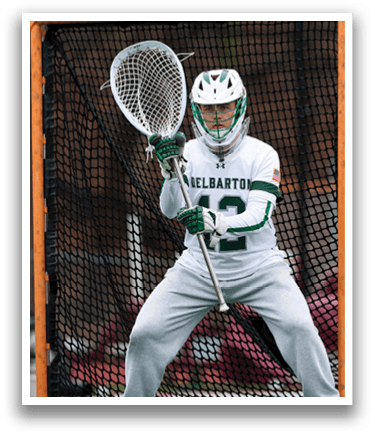 A man wearing a white shirt and gray pants is holding a lacrosse net. Description generated by AI