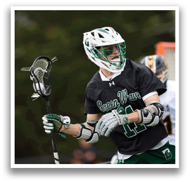 A man wearing a black shirt and holding a lacrosse stick. Description generated by AI