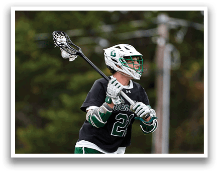 A man wearing a black shirt and green pants holding a lacrosse stick. Description generated by AI