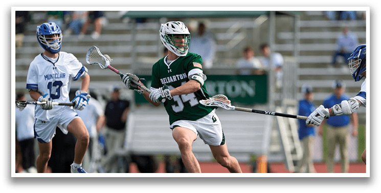 A man wearing a green shirt and white shorts is running with a lacrosse stick. Description generated by AI