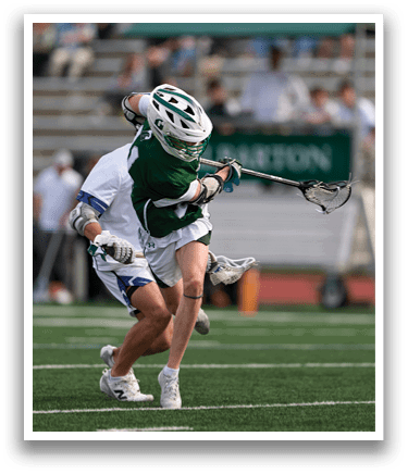 A man in a green and white uniform is running with a lacrosse stick. Description generated by AI