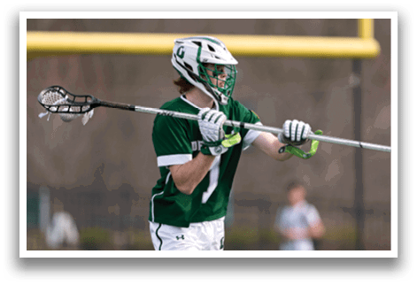 A man holding a lacrosse stick. Description generated by AI
