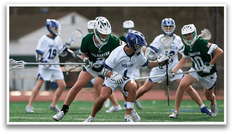 A group of people playing lacrosse on a field. Description generated by AI