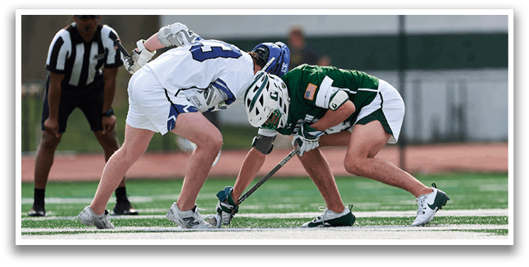 Two men playing a game of hockey on a field. Description generated by AI