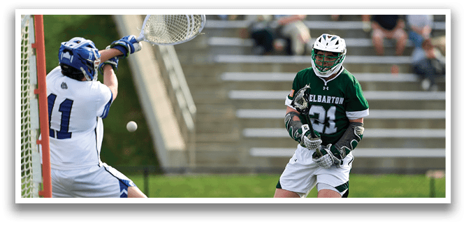 A man wearing a green and white jersey is playing lacrosse. Description generated by AI