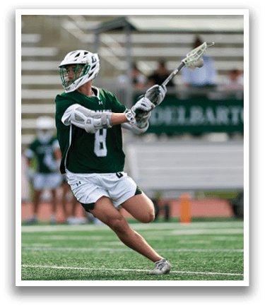 A man wearing a green and white uniform is playing lacrosse. Description generated by AI