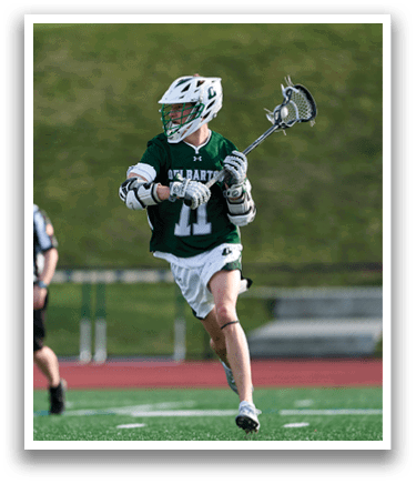 A man wearing a green and white jersey is running on a field. Description generated by AI