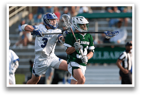 A man in a green jersey is trying to get past another man in a white jersey. Description generated by AI