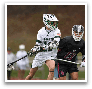 Two men playing lacrosse on a field. Description generated by AI