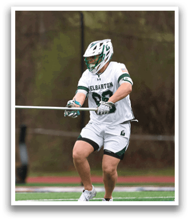Two men playing lacrosse on a field. Description generated by AI