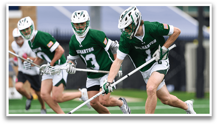 A man wearing a green and white jersey is running with a stick in his hand. Description generated by AI