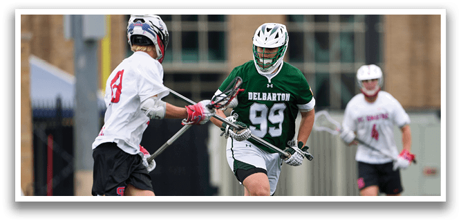 A man wearing a green shirt and white shorts is playing lacrosse. Description generated by AI