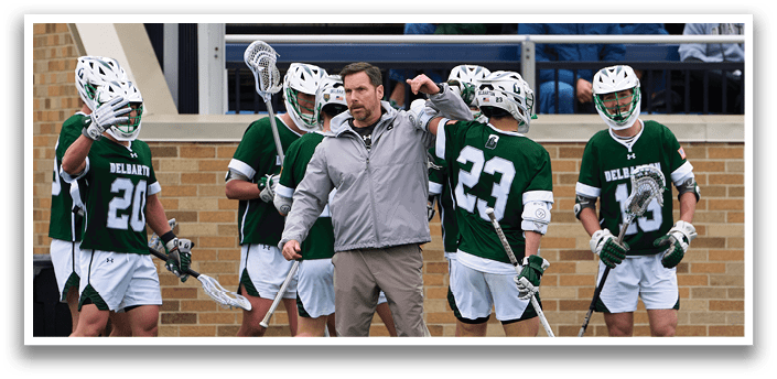 A group of men playing lacrosse. Description generated by AI