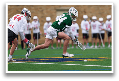 A man in a green and white uniform is playing lacrosse. Description generated by AI