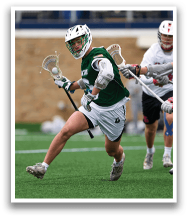 A man in a green shirt is running with a lacrosse stick. Description generated by AI