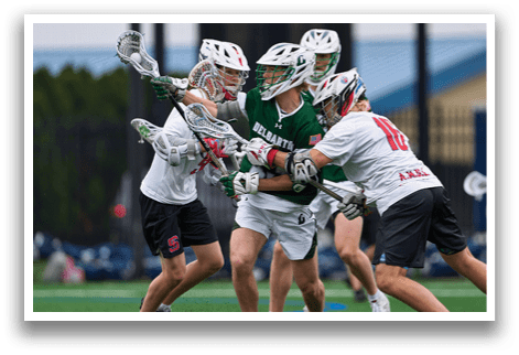 A group of people playing lacrosse. Description generated by AI