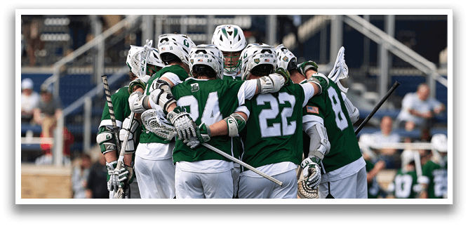 A group of men wearing green shirts and white shorts hugging each other. Description generated by AI