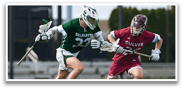Two men playing lacrosse on a field. Description generated by AI