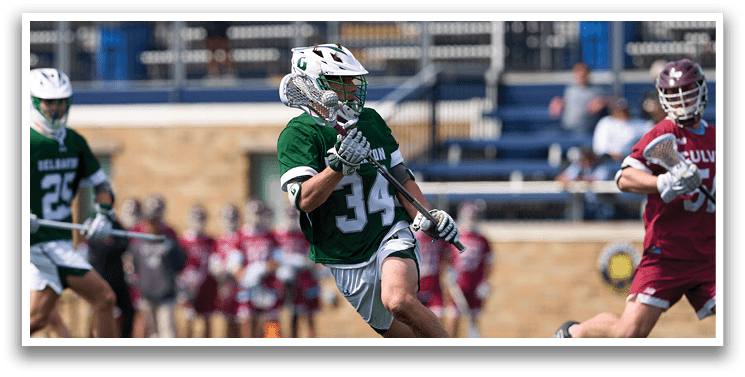 A man in a green and white uniform is running on a field with a baseball bat. Description generated by AI