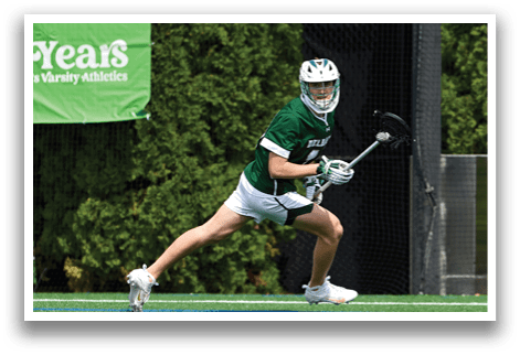 A man wearing a green and white jersey is running on a field. Description generated by AI
