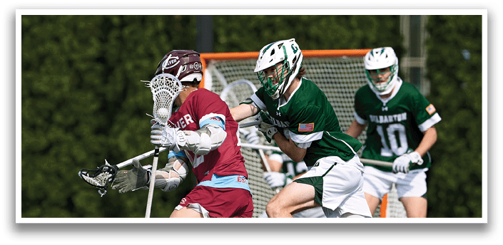A man wearing a maroon shirt is running with a lacrosse stick. Description generated by AI