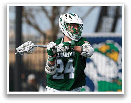 A man wearing a green and white jersey is holding a lacrosse stick. Description generated by AI