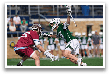 A man in a green and white uniform is holding a baseball bat. Description generated by AI
